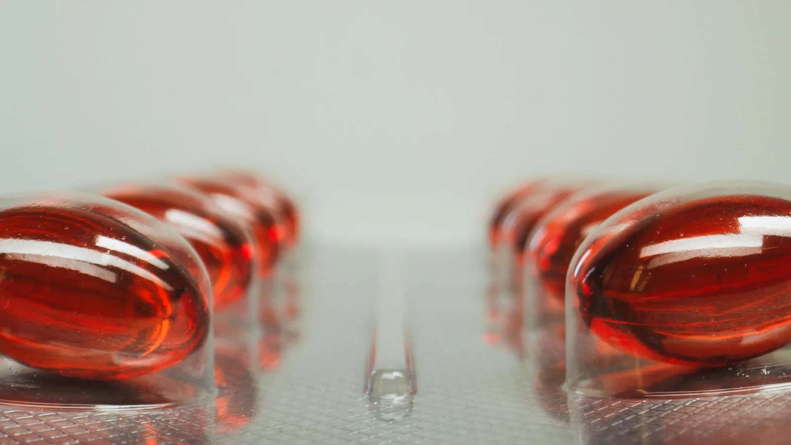 Supplements with cortisol claims: Macro shot of red capsules in a blister pack with selective focus on medicinal pills.