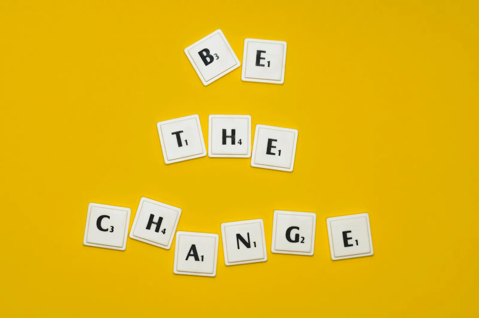 The behavior-change-vs-identity distinction: the word be the change spelled out with scrabbles