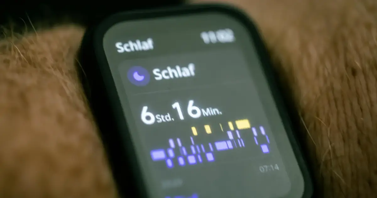 Close-up of a smartwatch displaying sleep tracking data in German.