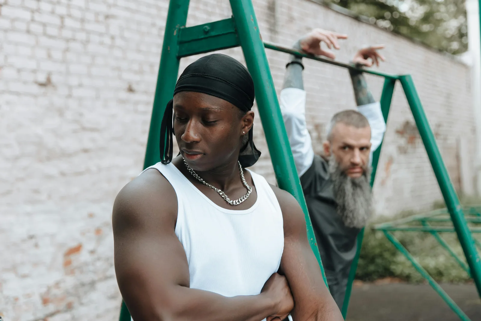 Men: testosterone across decades: Two men exercising on outdoor gym equipment. Captures strength and focus.