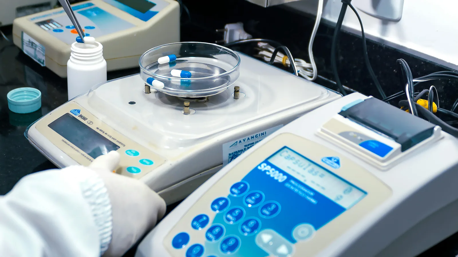 Reading a meta-analysis: Close-up of laboratory equipment with capsules, capturing pharmaceutical analysis.