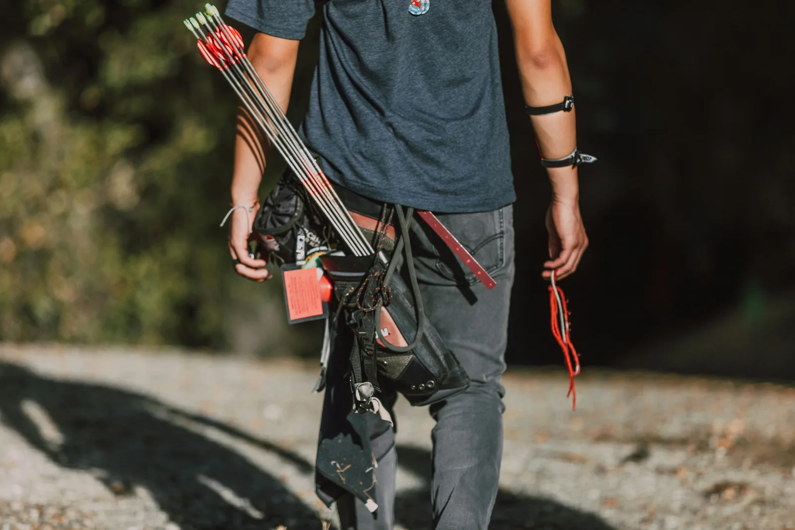 How do you lower ApoB and LDL?: A young archer with arrows and quiver walking outdoors in sunny weather.