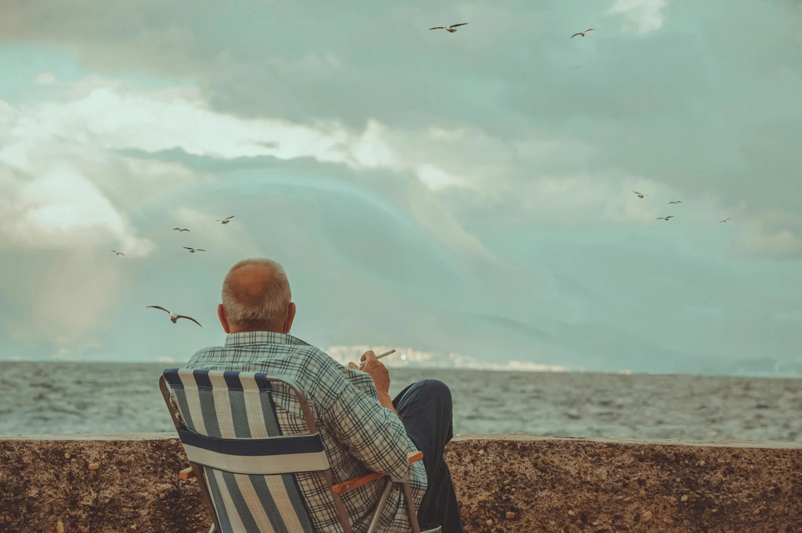 The TAME trial: An elderly man sits by the ocean, enjoying a peaceful moment under cloudy skies.