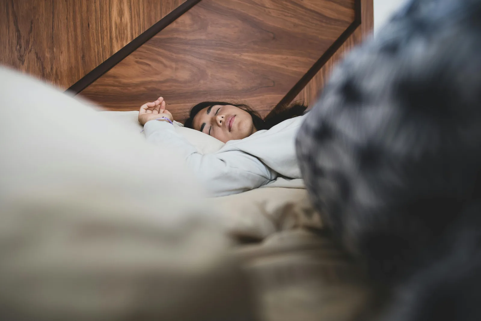 What NSDR is and where it comes from: A woman peacefully sleeping on a bed, conveying relaxation and comfort.