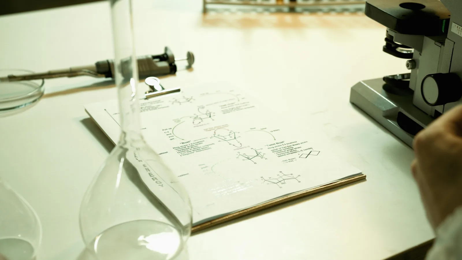 Expected effects and confidence intervals: Close-up of a laboratory setup with documents, beaker, and microscope on a table.