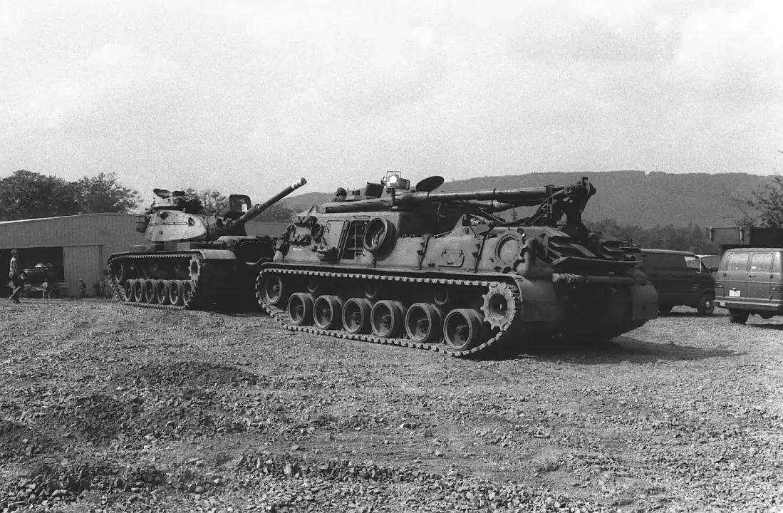Active recovery, NEAT, and Zone 1: A right side view of an M-88 armored recovery vehicle front and an M-60 main battle tank. The equipment is being prepare