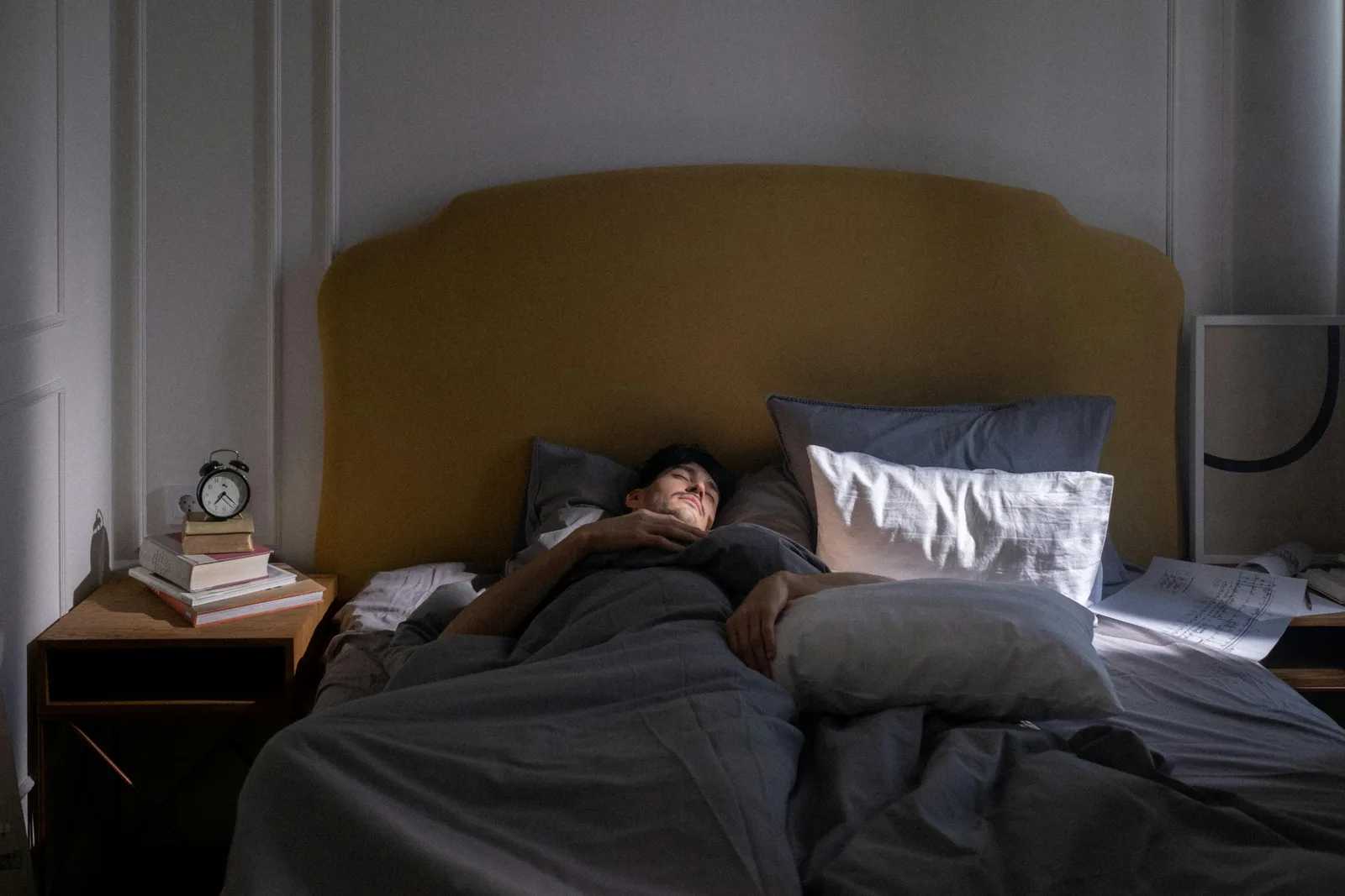 Magnesium glycinate, 200-400 mg with dinner: A man sleeping in a cozy bed with soft morning sunlight filtering in.