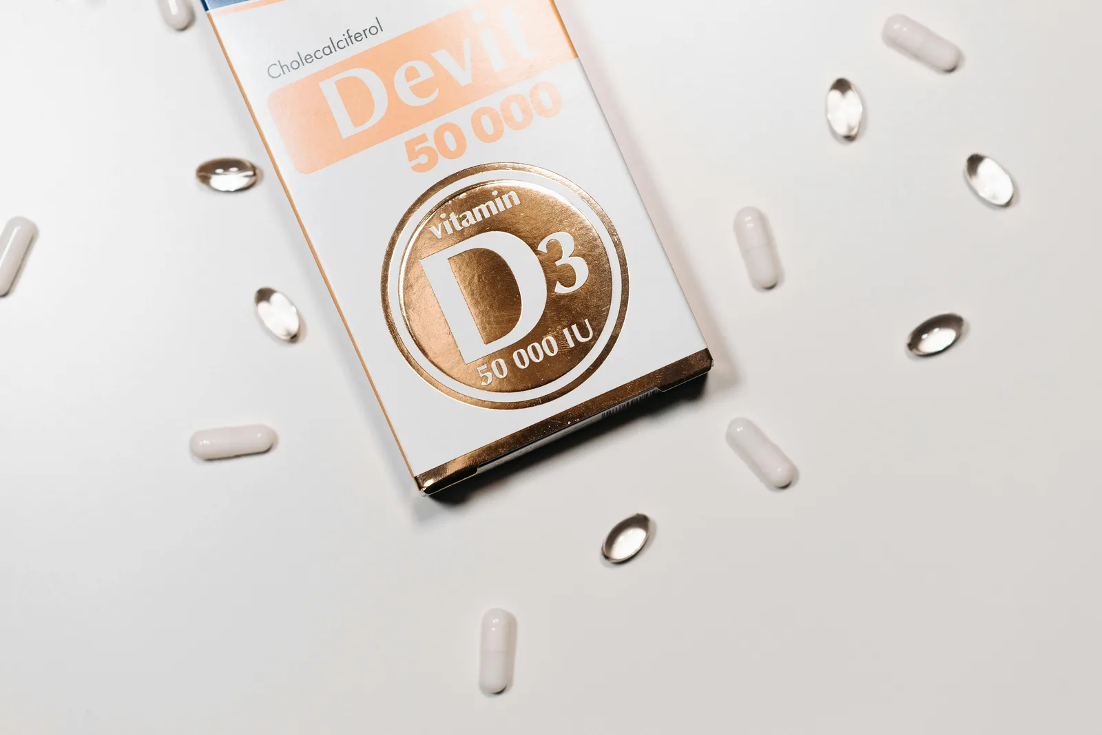 Magnesium and the vitamin D cofactor: Flat lay of Vitamin D3 supplement box and capsules on a light background.
